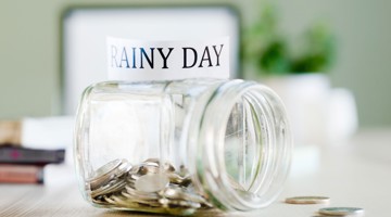 Un bocal en verre contenant de l'argent, avec une étiquette portant le texte « JOUR DE PLUIE ».