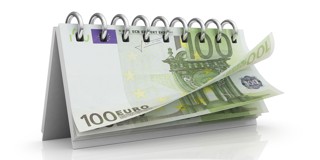 Une calendrier de table avec une page ouverte et un billet de 100 euros visible.
