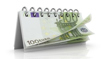 Une calendrier de table avec une page ouverte et un billet de 100 euros visible.