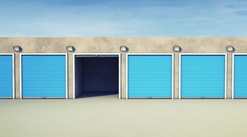 Vue d'une rangée d'espaces de stockage avec des volets bleus, la porte de l'espace de stockage numéro 3 est ouverte.