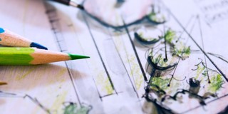 Tekeningen en schetsen van een tuinontwerp, zichtbaar vooraan met groene en blauwe kleurpotloden.