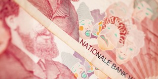 Detail van een bankbiljet met afbeeldingen van historische figuren en kleurrijke clownachtige gezichten, met de tekst NATIONALE BANK.