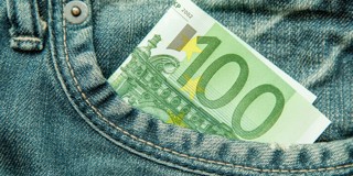 Een honderd euro biljet in de achterzak van een spijkerbroek.