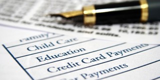 Een gestructureerd document met een lijst van uitgavencategorieën zoals kinderopvang, onderwijs en creditcardbetalingen, naast een luxe vulpen.