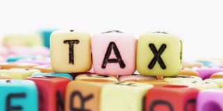 Kleurige blokken met letters, met de letters 'TAX' prominent in het midden.
