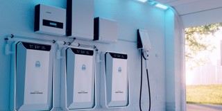 Drie moderne oplaadstations voor elektrische voertuigen tegen een wand, met een laadkabel aan de rechterkant en sfeervolle blauwverlichte accenten.