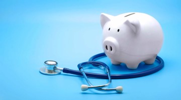 Een witte spaarpot naast een blauwe stethoscoop, die de relatie tussen mentale gezondheid en financiële welzijn symboliseert.