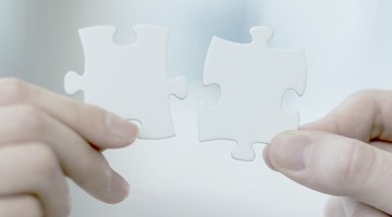 Deux pièces de puzzle blanches sont maintenues ensemble.
